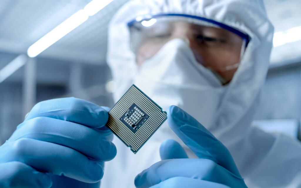 person holds semiconductor in hand Amkor stock semiconductor stock AMKR stock Micron stock MU stock